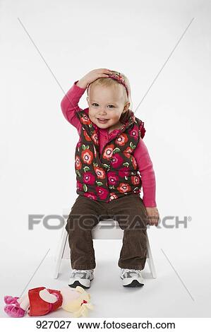 Stock Photo - Portrait of a young child with her hand on top of her head. Fotosearch