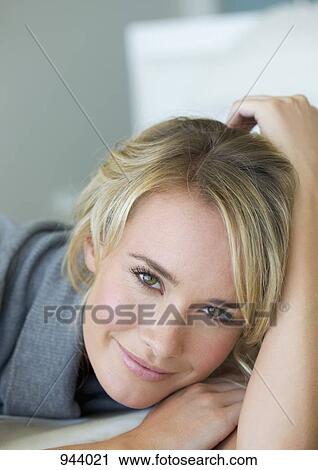 Portrait of a young woman lying on a bed View Large Photo Image Stock Image - Portrait of a young woman lying on a bed. Fotosearch
