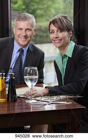 Two business people sitting at a restaurant View Large Photo Image Stock Photo - Two business people sitting at a restaurant. Fotosearch