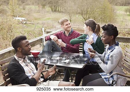 Two couples playing cards, outdoors View Large Photo Image Stock Photography - Two couples playing cards, outdoors. Fotosearch