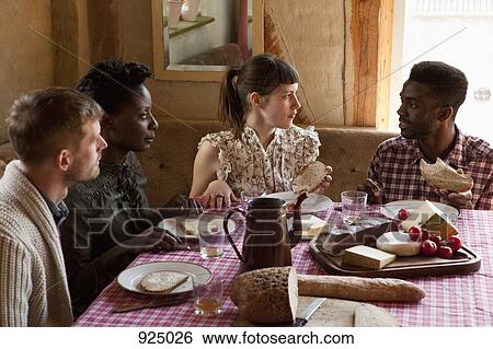 Stock Photograph - Two couples talking and eating. Fotosearch