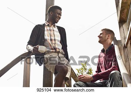 Two friends sitting on a staircase View Large Photo Image Picture - Two friends sitting on a staircase. Fotosearch