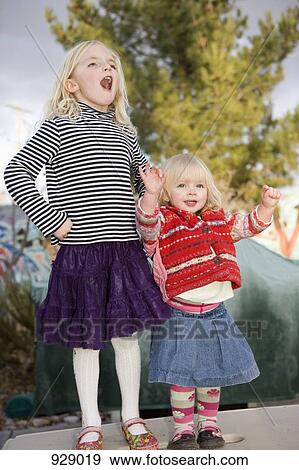 Two girls standing side by side View Large Photo Image Stock Photo - Two girls standing side by side. Fotosearch