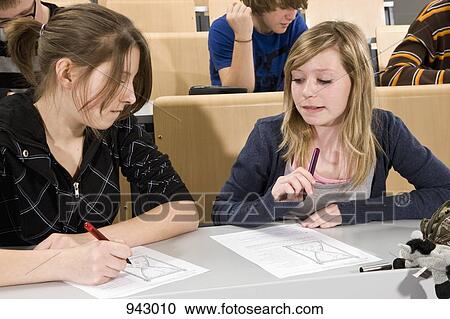 Stock Image - Two students working on worksheets together. Fotosearch