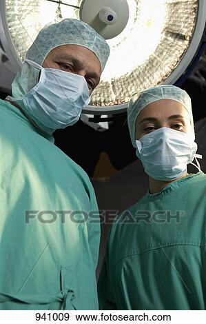 Two surgery staff standing in an operating room View Large Photo Image Stock Photo - Two surgery staff standing in an operating room. Fotosearch