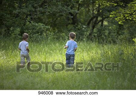 Two young boys walking outdoors in summer View Large Photo Image Stock Photo - Two young boys walking outdoors in summer. Fotosearch