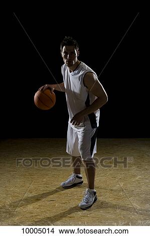 A basketball player dribbling a ball, portrait, studio shot View Large Photo Image Picture - A basketball player dribbling a ball, portrait, studio shot. Fotosearch