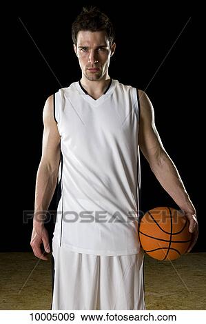 Stock Photo - A basketball player, portrait, studio shot. Fotosearch