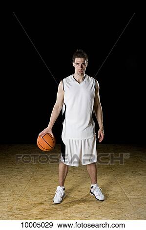 Stock Photo - A basketball player, portrait, studio shot. Fotosearch
