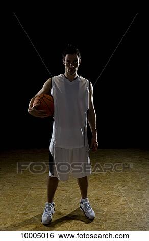 Stock Photograph - A basketball player, portrait, studio shot. Fotosearch