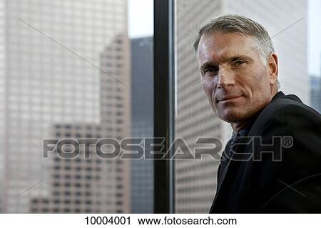 A businessman by a window View Large Photo Image Stock Image - A businessman by a window. Fotosearch