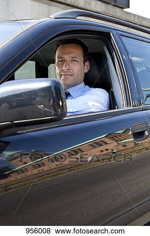 A businessman in his car, looking at camera View Large Photo Image Stock Photo - A businessman in his car, looking at camera. Fotosearch