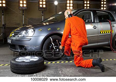 A crash test dummy changing a tire View Large Photo Image Stock Photo - A crash test dummy changing a tire. Fotosearch