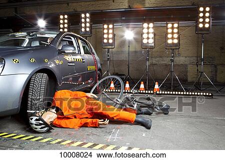 Picture - A crash test dummy on ground after bicycle crashed into car. Fotosearch