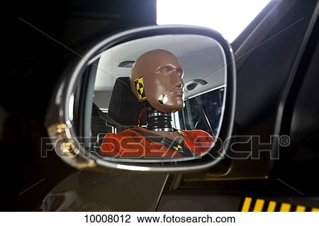 Stock Image - A crash test dummy reflected in a side-view mirror. Fotosearch