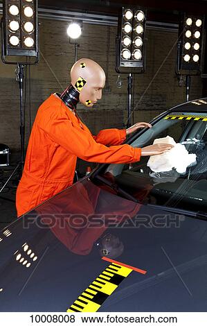 Stock Photo - A crash test dummy washing the windshield of a crash test car. Fotosearch