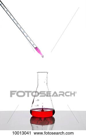 Stock Image - A dropper putting fluid into a beaker. Fotosearch