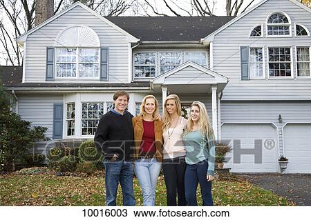 A family of four standing in front of their home View Large Photo Image Stock Image - A family of four standing in front of their home. Fotosearch