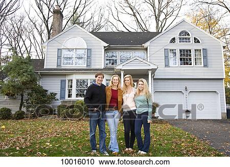 A family of four standing in front of their home View Large Photo Image Stock Image - A family of four standing in front of their home. Fotosearch