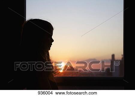 A girl by a window at sunset View Large Photo Image Picture - A girl by a window at sunset. Fotosearch