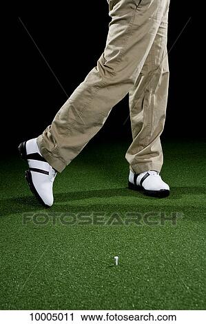 Stock Image - A golfer, low section, studio shot. Fotosearch
