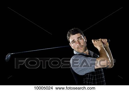 A golfer swinging a club, portrait, studio shot View Large Photo Image Picture - A golfer swinging a club, portrait, studio shot. Fotosearch