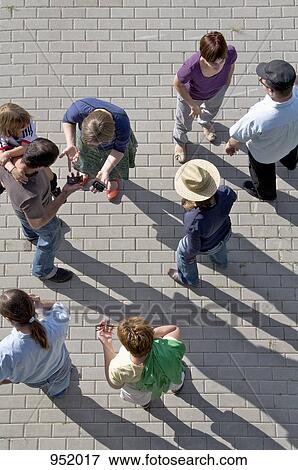 A group of people standing on a plaza View Large Photo Image Stock Photo - A group of people standing on a plaza. Fotosearch