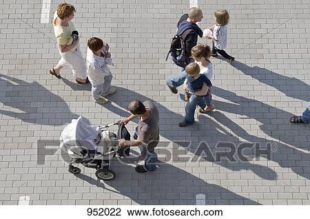 A group of people walking through a parking lot View Large Photo Image Stock Image - A group of people walking through a parking lot. Fotosearch