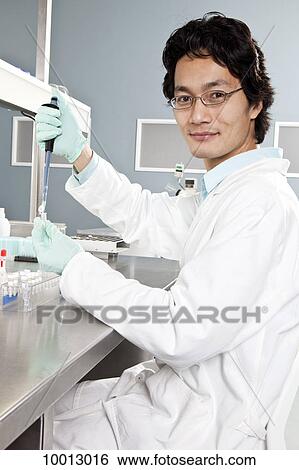 A lab technician using a pipette to put a sample into a vial, looking at camera View Large Photo Image Stock Photograph - A lab technician using a pipette to put a sample into a vial, looking at camera. Fotosearch