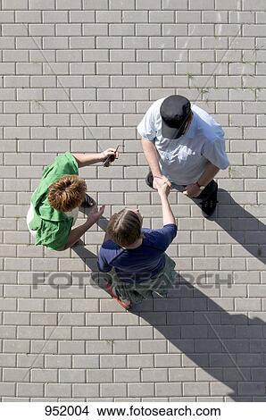 Picture - A man introducing a friend to another friend. Fotosearch