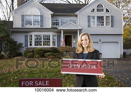 A real estate agent holding an OPEN HOUSE sign View Large Photo Image Picture - A real estate agent holding an OPEN HOUSE sign. Fotosearch