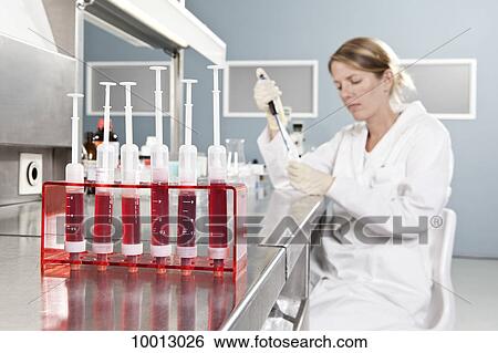 A row of vials holding blood and a lab technician working in background, focus on foreground View Large Photo Image Stock Photograph - A row of vials holding blood and a lab technician working in background, focus on foreground. Fotosearch