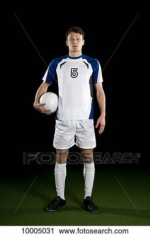 Stock Image - A soccer player, portrait, studio shot. Fotosearch