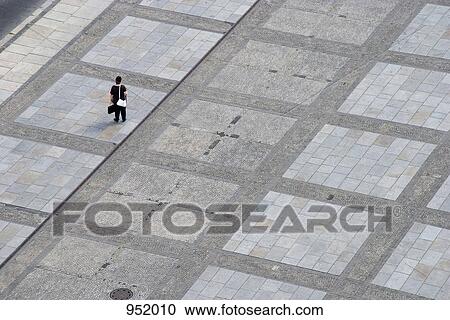 A woman standing alone on an urban plaza View Large Photo Image Stock Image - A woman standing alone on an urban plaza. Fotosearch