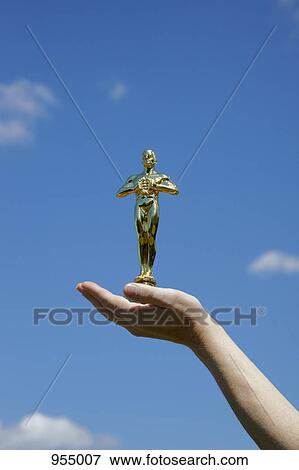 Hand holding statuette View Large Photo Image Stock Photo - Hand holding statuette. Fotosearch