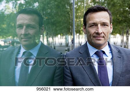 Portrait of a businessman leaning against a window, outdoors View Large Photo Image Stock Image - Portrait of a businessman leaning against a window, outdoors. Fotosearch