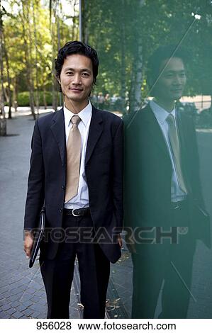 Portrait of a businessman leaning against a window, outdoors View Large Photo Image Stock Photo - Portrait of a businessman leaning against a window, outdoors. Fotosearch