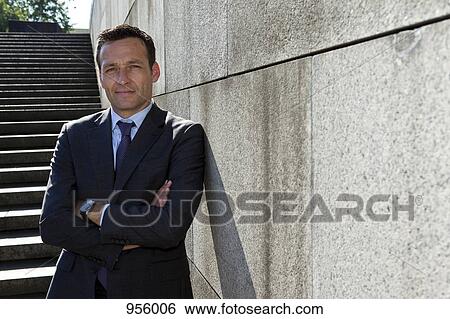 Portrait of a businessman leaning against a wall, outdoors View Large Photo Image Stock Photograph - Portrait of a businessman leaning against a wall, outdoors. Fotosearch