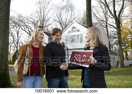 Real estate agent shaking hands with a couple View Large Photo Image Stock Image - Real estate agent shaking hands with a couple. Fotosearch