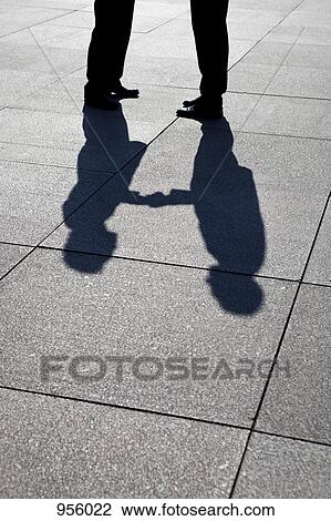 The shadow of two businessmen shaking hands, focus on shadow View Large Photo Image Stock Image - The shadow of two businessmen shaking hands, focus on shadow. Fotosearch