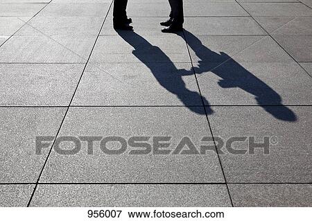 The shadow of two businessmen shaking hands, focus on shadow View Large Photo Image Stock Photo - The shadow of two businessmen shaking hands, focus on shadow. Fotosearch