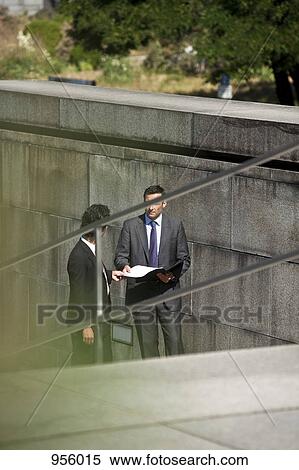 Two businessmen conducting suspicious business View Large Photo Image Stock Photography - Two businessmen conducting suspicious business. Fotosearch