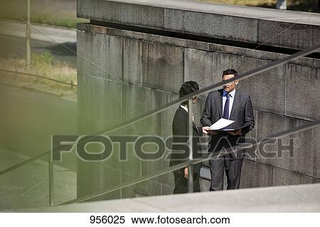 Two businessmen conducting suspicious business View Large Photo Image Stock Photography - Two businessmen conducting suspicious business. Fotosearch