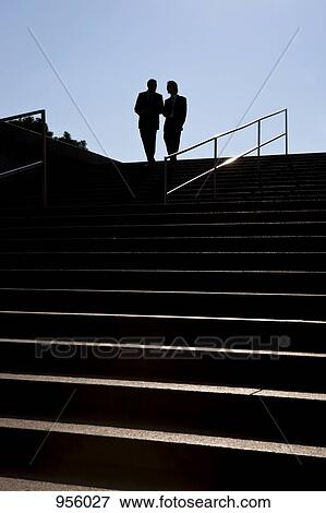 Stock Photo - Two businessmen meeting outdoors, silhouette. Fotosearch