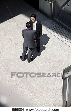 Two businessmen talking, outdoors View Large Photo Image Picture - Two businessmen talking, outdoors. Fotosearch