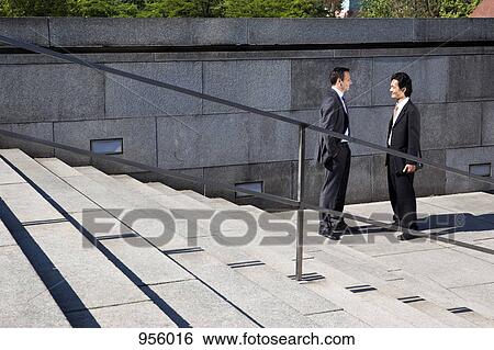 Stock Photograph - Two businessmen talking, outdoors. Fotosearch