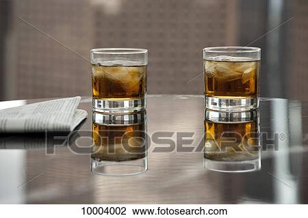 Two glasses of whiskey and ice on a table View Large Photo Image Stock Image - Two glasses of whiskey and ice on a table. Fotosearch