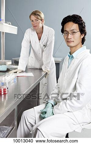 Two lab technicians in a laboratory, looking at camera View Large Photo Image Stock Image - Two lab technicians in a laboratory, looking at camera. Fotosearch