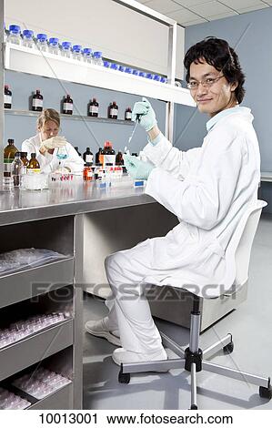 Two lab technicians working in a laboratory, focus on man in foreground View Large Photo Image Stock Image - Two lab technicians working in a laboratory, focus on man in foreground. Fotosearch