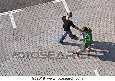 Two strangers pass each other walking through a parking lot View Large Photo Image Stock Photo - Two strangers pass each other walking through a parking lot. Fotosearch